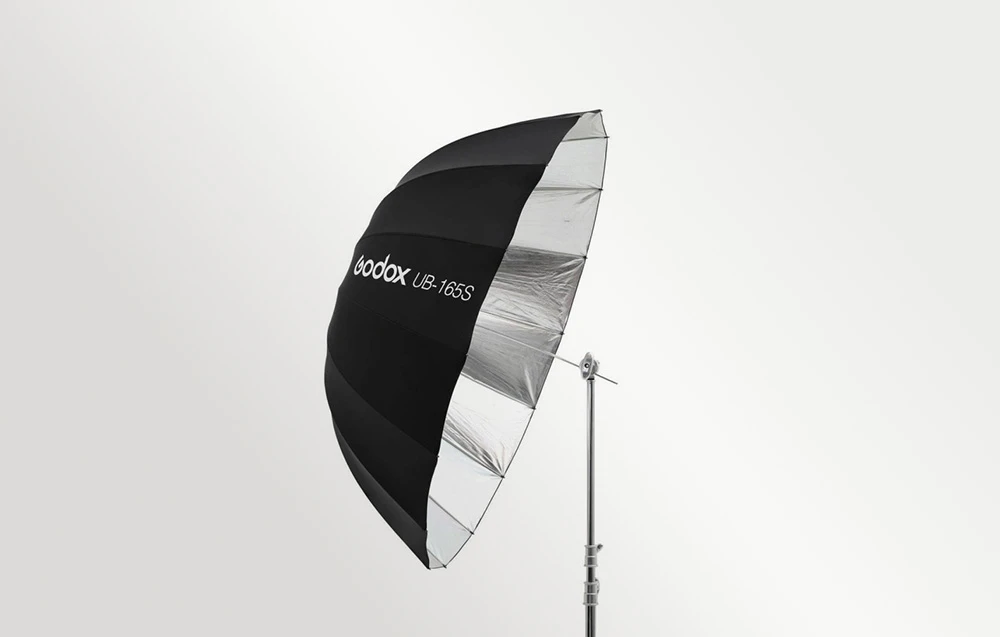 O umbrelă neagră poziționată lateral față de aparatul foto.