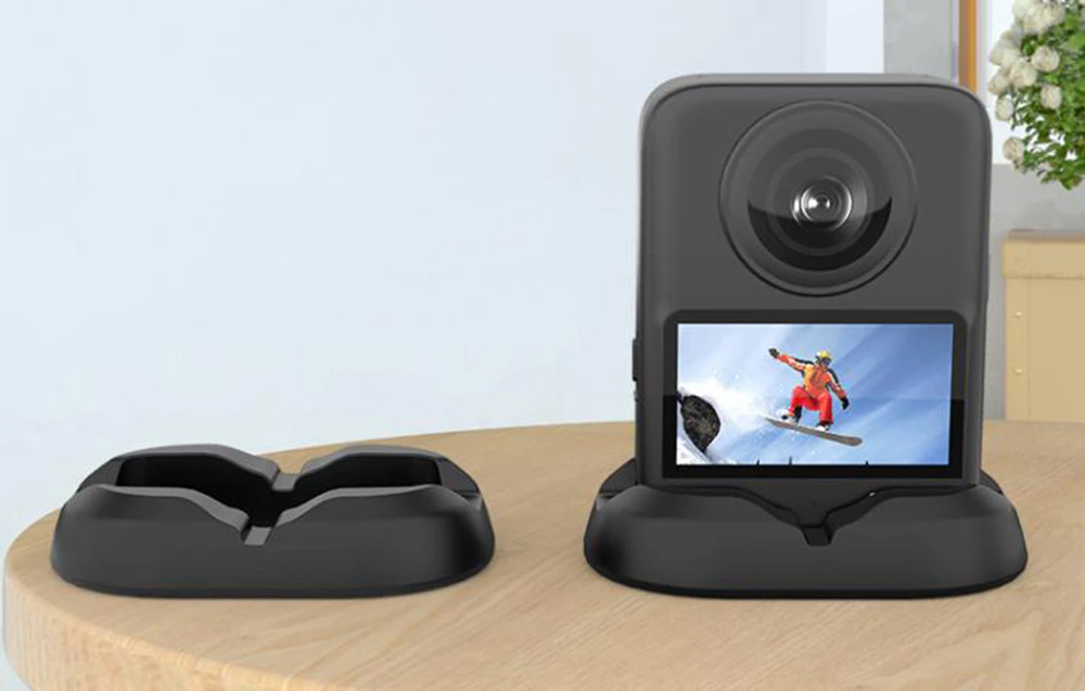 Cameră de 360 de grade amplasată pe un suport negru pe o masă de lemn, un alt suport lângă ea
