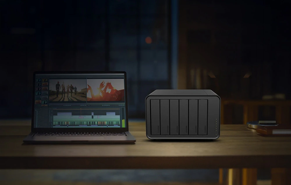 O carcasă NAS cu șase compartimente pentru unități de stocare se află lângă un laptop pe care este deschis un program de editare video