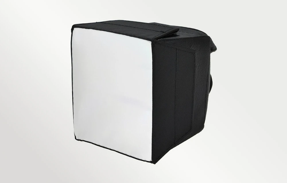 Un difuzor softbox pătrat, negru, cu o suprafață de difuzie albă, prezentat într-un unghi pe un fundal deschis