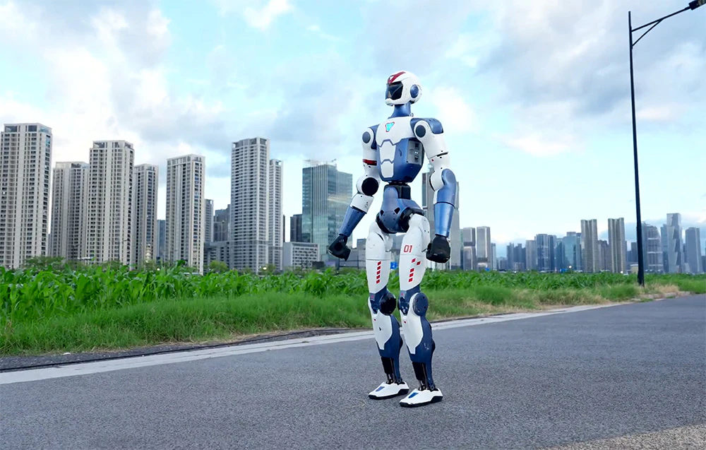 Un robot umanoid care stă pe o șosea, pe fundalul unui oraș modern cu zgârie-nori