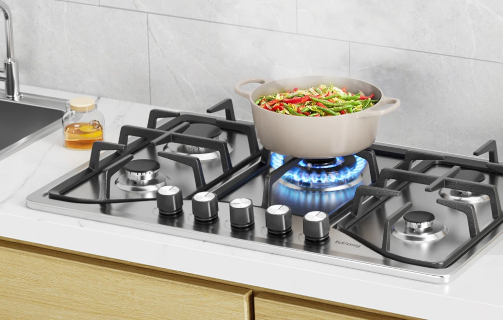 Plită pe gaz cu oală bej cu legume pe flacără albastră în bucătărie luminoasă