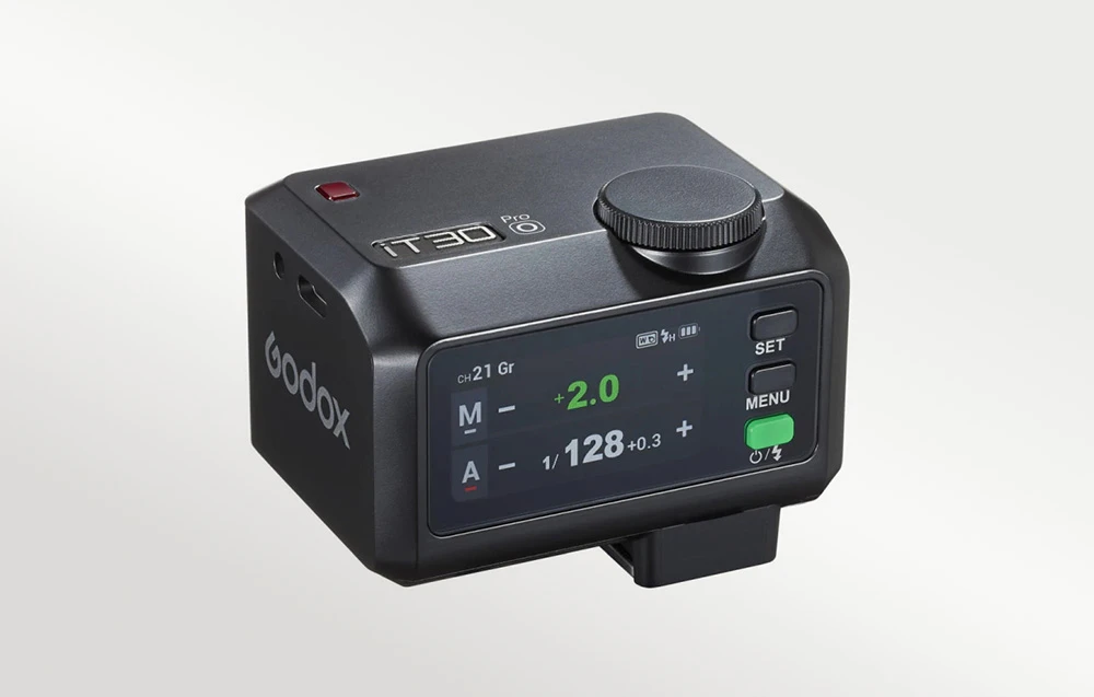 Un mini-blitz Godox iT30Pro S negru cu ecranul LCD pornit, afișând setările blitzului