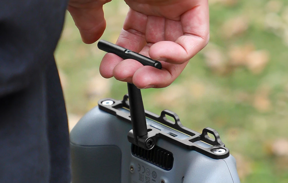 Bărbat purtând controlerul DJI cu ajutorul suportului Sunnylife.