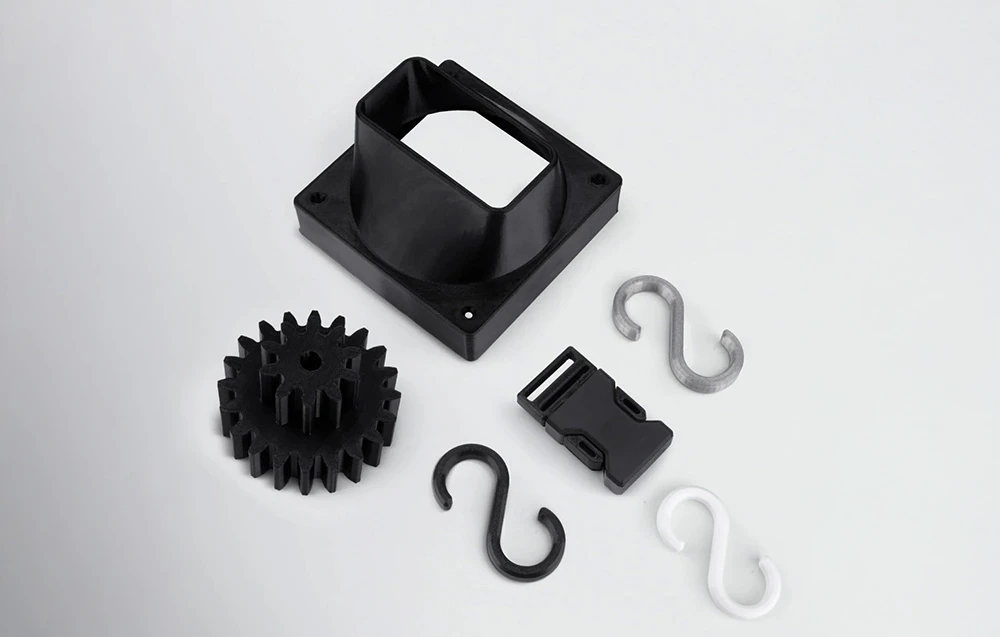 Imprimare 3D alb-negru realizată din filament Elegoo, incluzând angrenaj, cârlige și carcasă