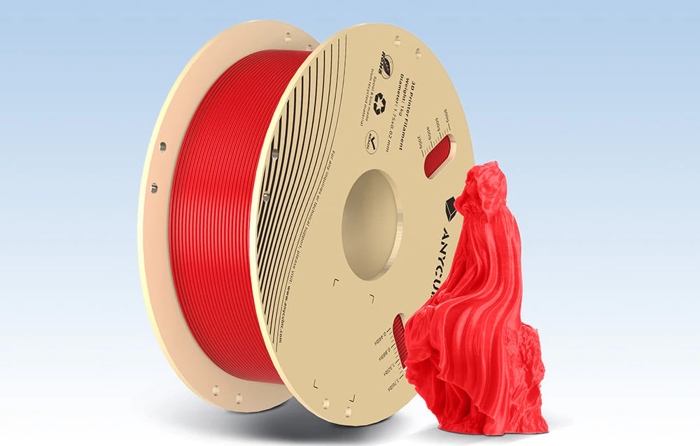 Filamanet roșu Anycubic cu model imprimat 3D lângă el pe un fundal albastru.