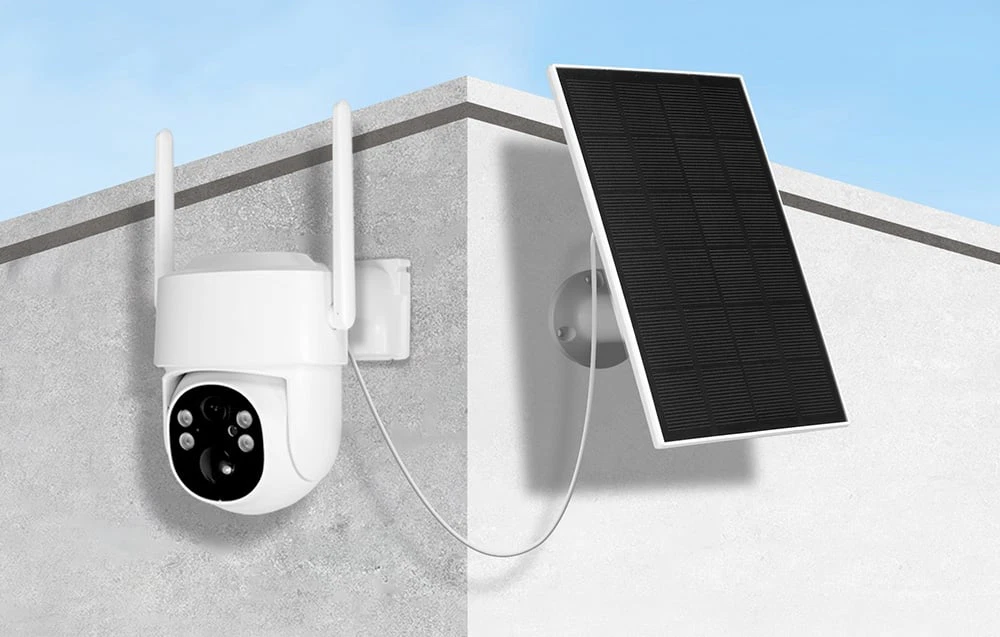 O cameră PTZ albă cu două antene și un panou solar montată pe colțul unui zid de beton