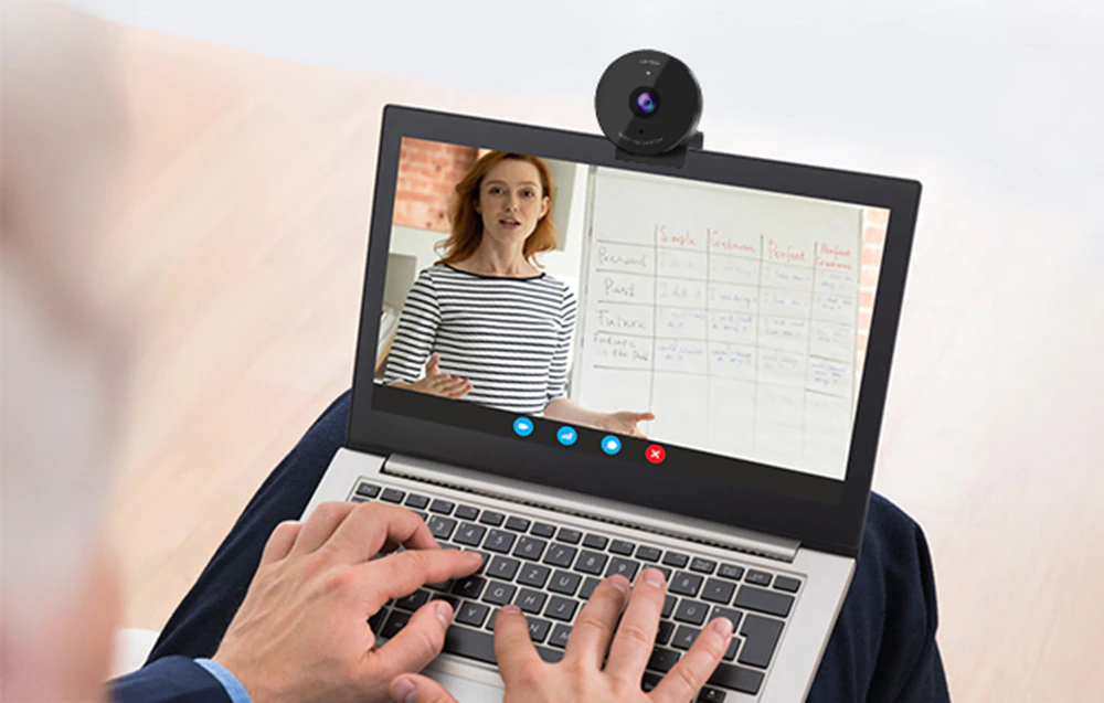 Vedere a ecranului unui laptop cu cameră, care prezintă o lecție online condusă de un profesor.