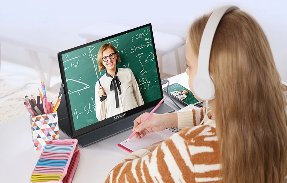 O fată care poartă căști și participă la un curs online pe un monitor portabil