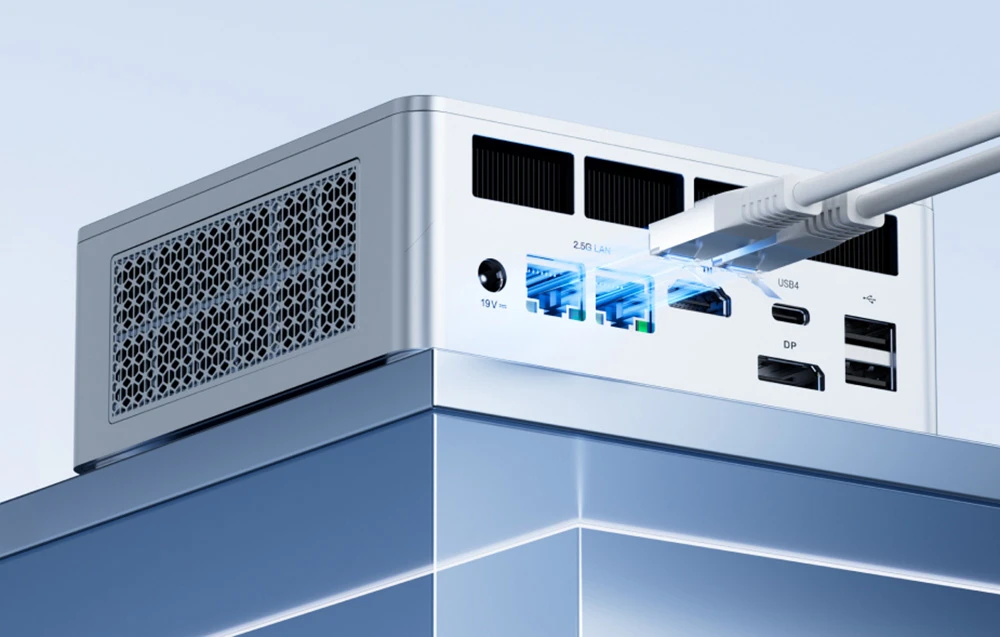 Panoul din spate al unui mini PC argintiu cu porturi LAN, HDMI, DP și USB și cabluri albe conectate