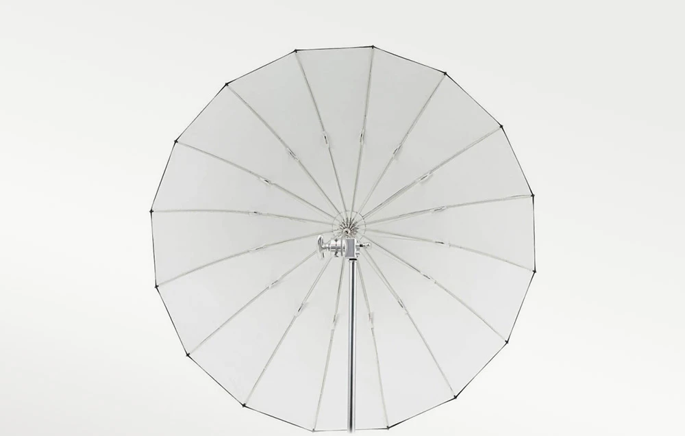 O umbrelă argintie deschisă, poziționată cu fața spre aparatul foto, pe un fundal deschis.