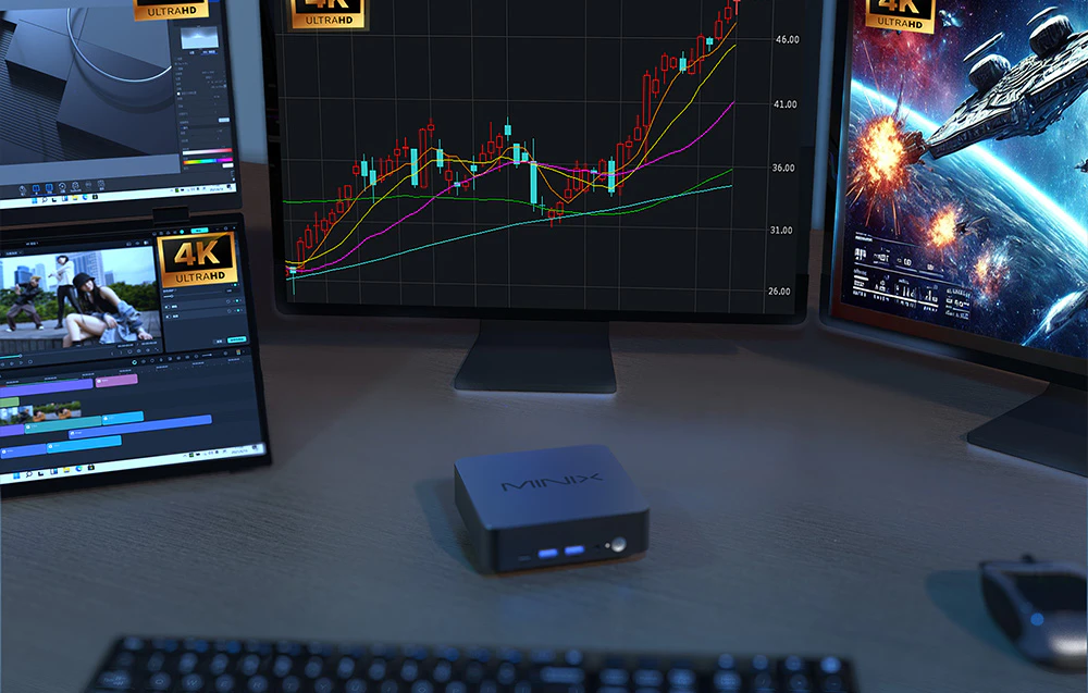 Mini PC Minix N512 așezat pe un birou, cu patru monitoare care rulează diverse programe în fundal și o tastatură în prim-plan.