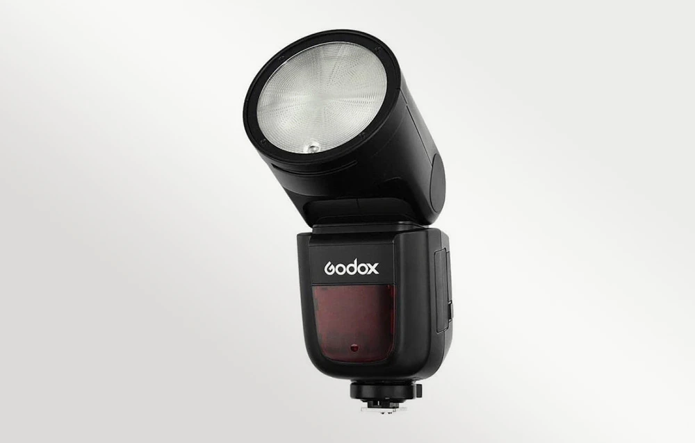Bliț rotund Godox V1 cu capul ridicat, montat pe un hot shoe, vedere frontală