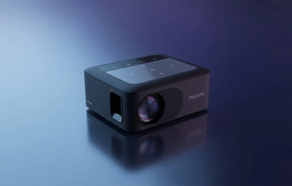 Un proiector PHILIPS negru cu inscripția „HDMI” pe lateral, prezentat într-un unghi pe un fundal albastru uniform