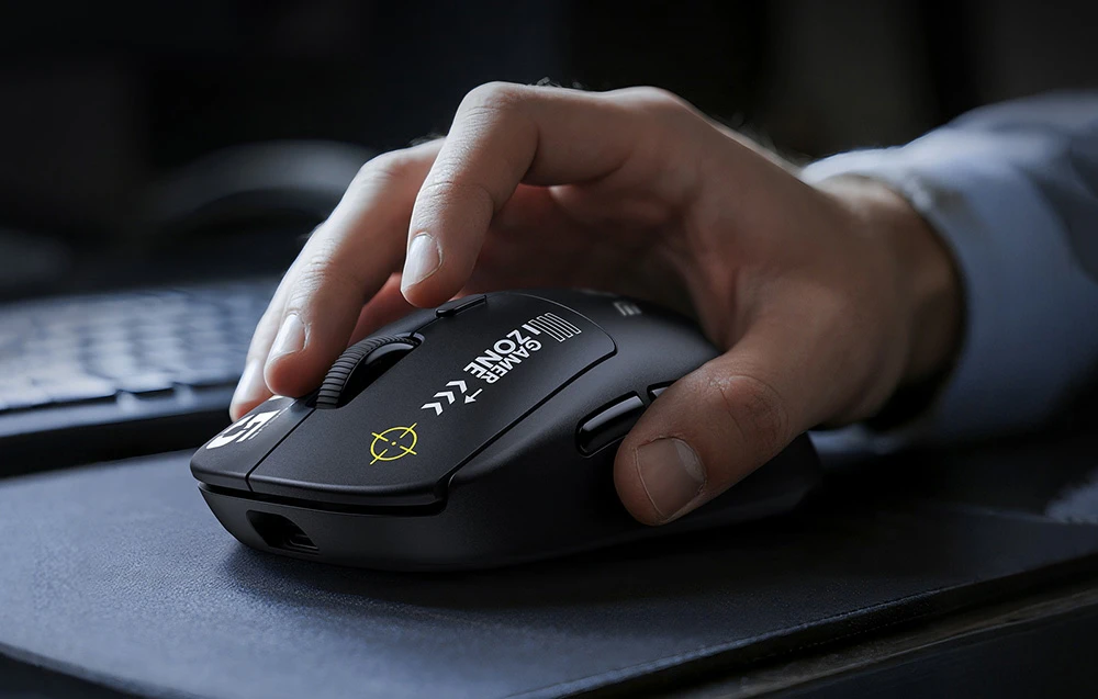 Prim-plan al unei mâini așezate pe un mouse de computer negru