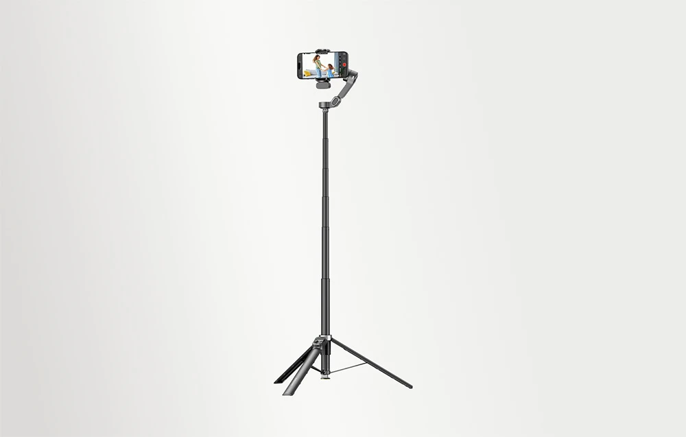 Un gimbal negru pentru telefon pe un trepied, pe un fundal gri