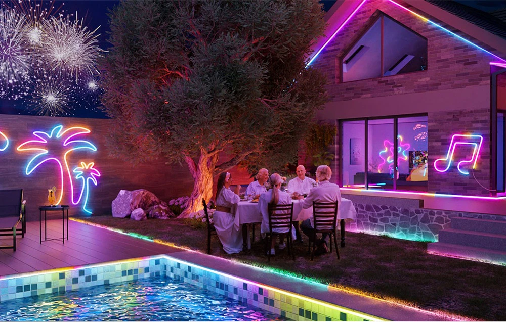 O familie stă la masă în fața casei, lângă piscină; curtea este iluminată cu benzi LED colorate