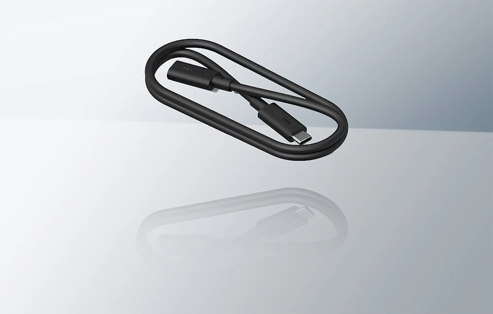 Cablu USB-C negru spiralat de la VITURE alături de reflexia sa pe o suprafață strălucitoare și luminoasă