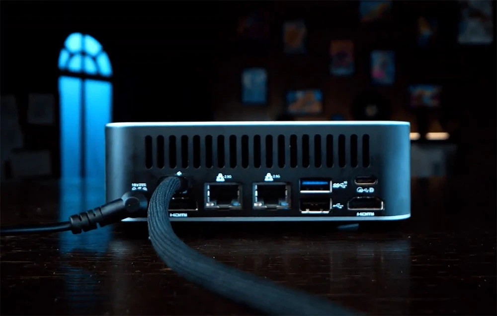 Prim-plan al porturilor unui MINI PC așezat pe un birou într-o cameră întunecată