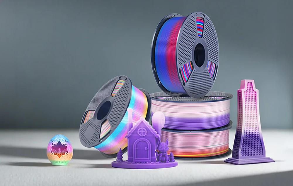 Bobine de filament SUNLU Rainbow și mostre de imprimări 3D colorate pe o masă