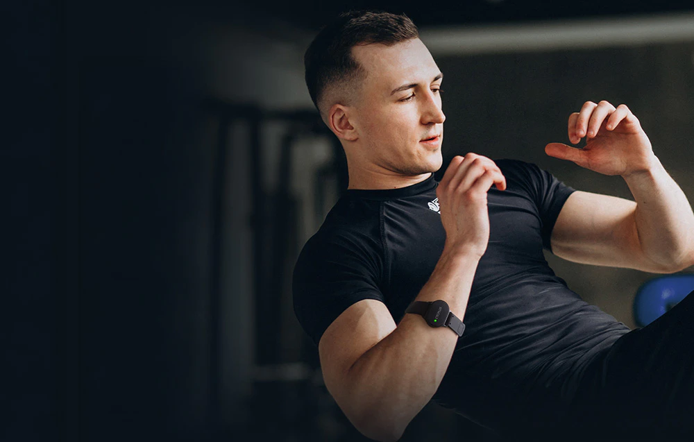 Bărbat în tricou de antrenament negru cu brățară Cycplus H1 în timp ce face exerciții la sală