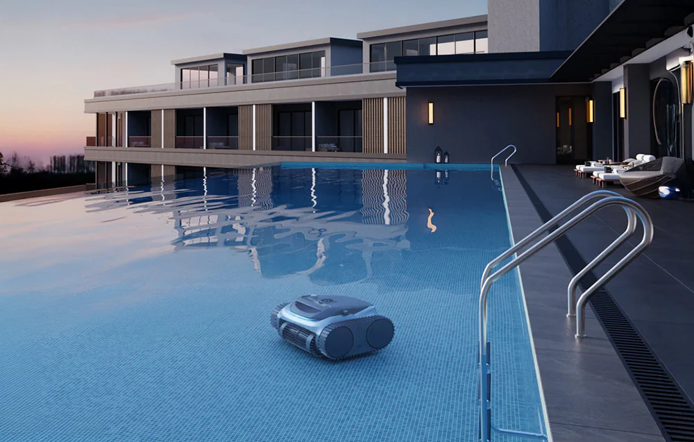 Robot de piscină curățând fundul unei piscine mari lângă o clădire