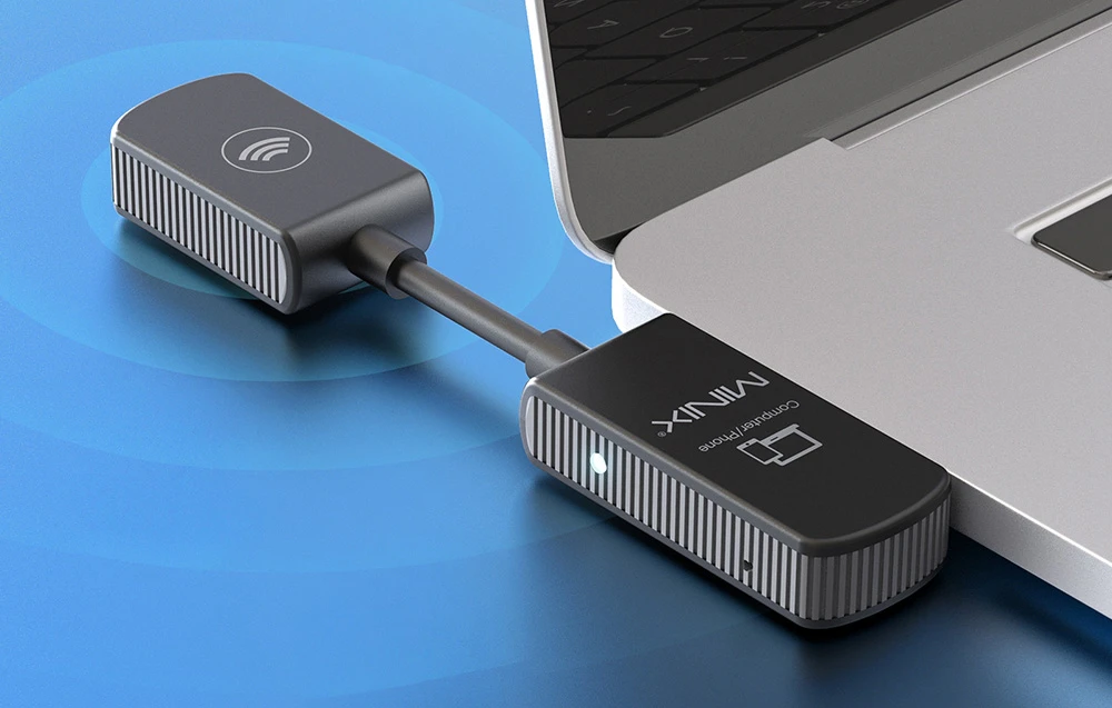Adaptor MINIX cu eticheta „Computer/Phone” conectat la portul USB-C al unui laptop pe un fundal albastru