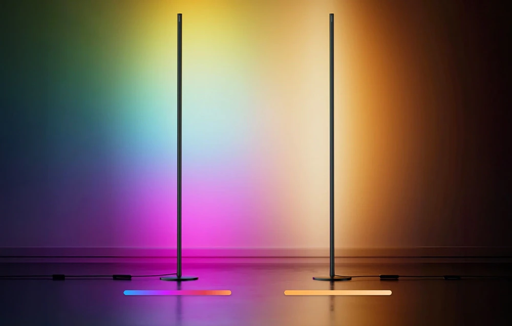 Două lămpi de podea minimaliste, dintre care una emite lumină multicoloră, iar cealaltă lumină caldă, galbenă.