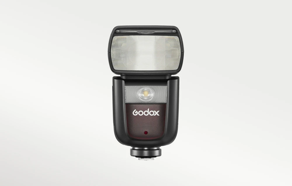Vedere frontală a blițului Godox V860III cu LED-ul de umplere vizibil și receptorul roșu pe corp