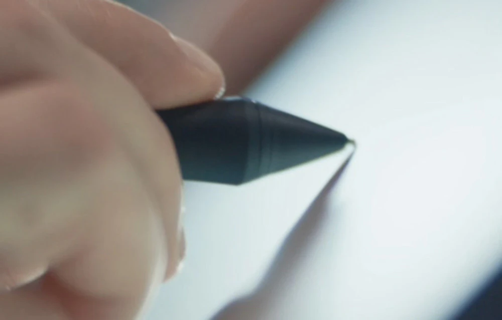 Mână care ține un stylus negru cu mâner din cauciuc pe fundal alb