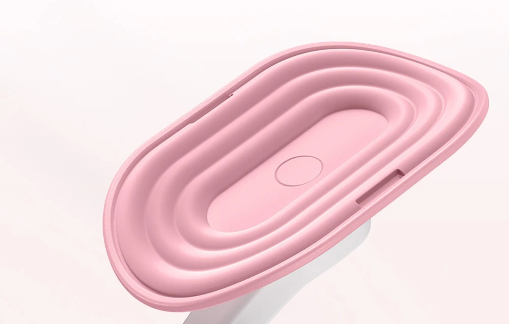 Prim-plan înclinat al unui tampon oval, roz, cu adâncituri conturate, atașat la brațul alb al dispozitivului