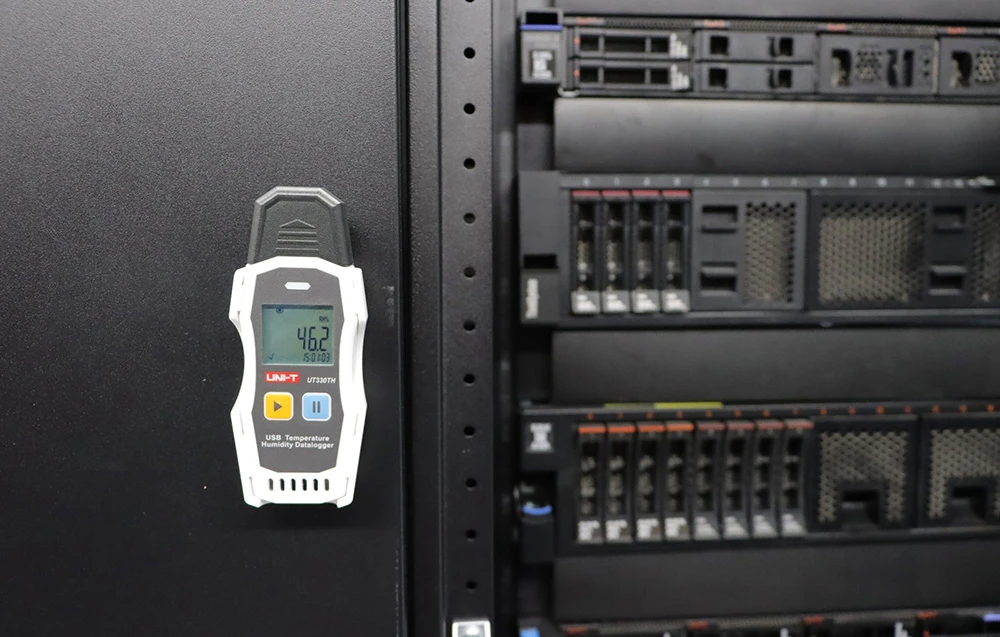 Termohigrometru digital Uni-T USB cu funcție de înregistrare a datelor montat pe un perete negru