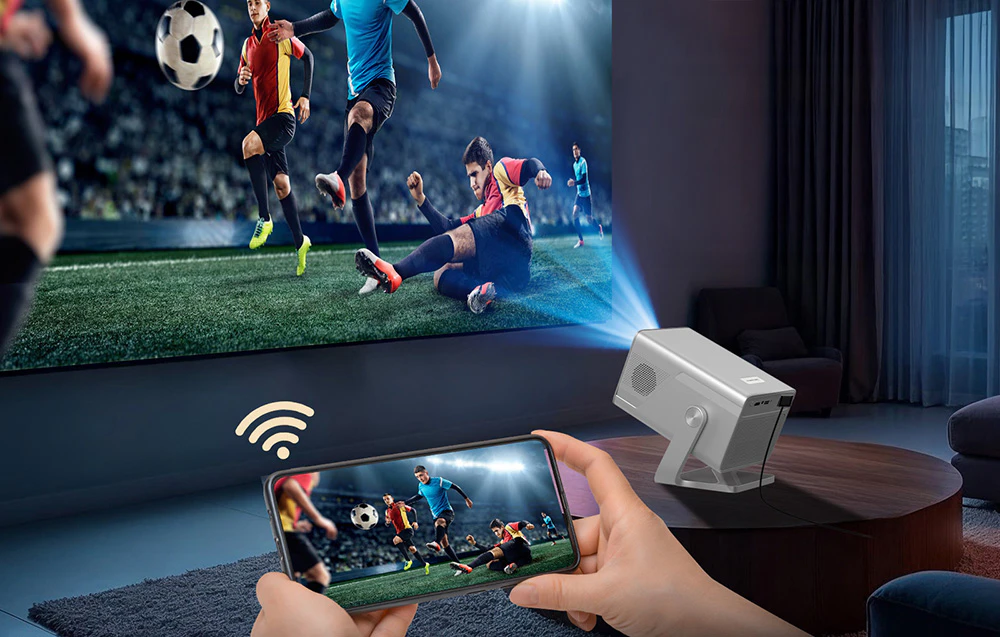Un proiector afișează un meci de fotbal, care este vizibil simultan pe ecranul unui smartphone ținut în mână