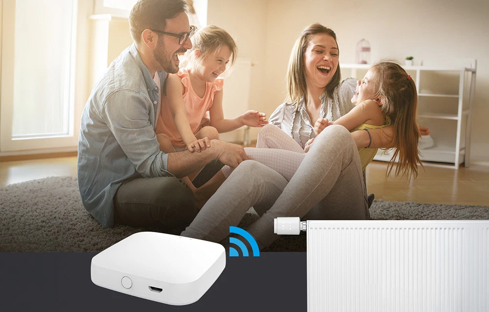 O familie zâmbitoare care se joacă în sufragerie, unde este instalat un termostat inteligent controlat de un panou de control.