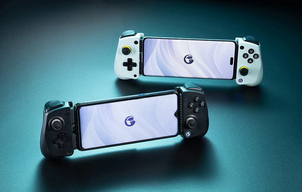 Două controlere GameSir cu smartphone-uri montate, modele albe și negre, poziționate pe o suprafață albastră.
