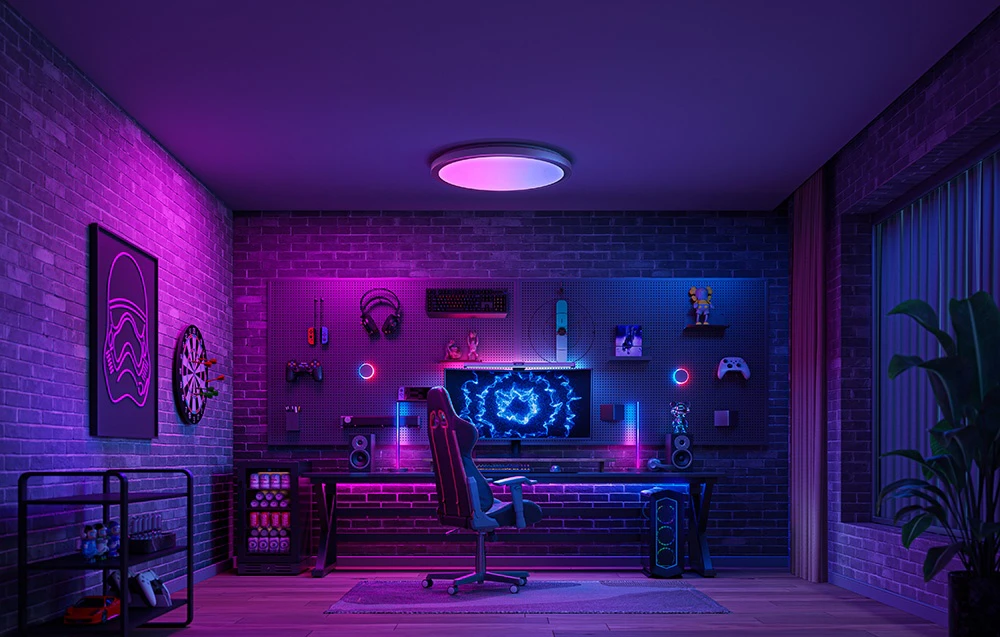 Sală de jocuri cu iluminare de fundal în violet și roz, cu lampa Yeelight Jupiter D C400 deasupra stației de lucru a computerului.