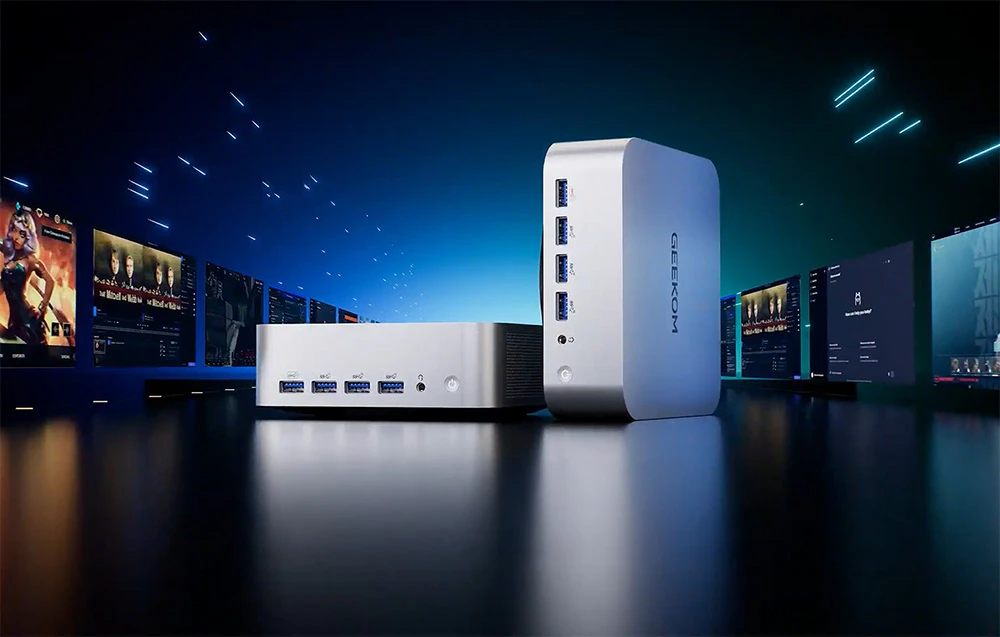 2 mini PC-uri Geekom gri pe un blat negru, monitoare pe laterale
