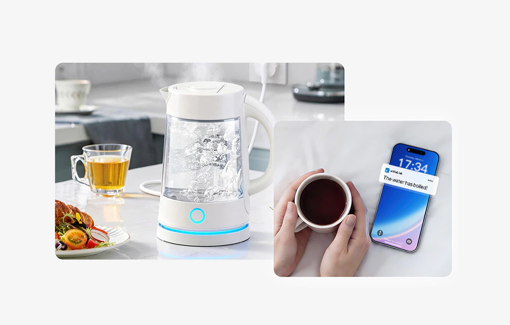 Un ceainic electric pe masa din bucătărie lângă un pahar și o farfurie cu mâncare, cu o cană de cafea ținută în mâini și un smartphone care afișează o notificare