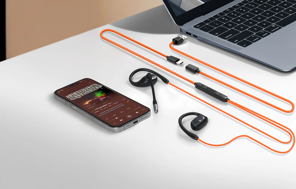 Smartphone, căști cu fir cu microfon și laptop pe un birou alb