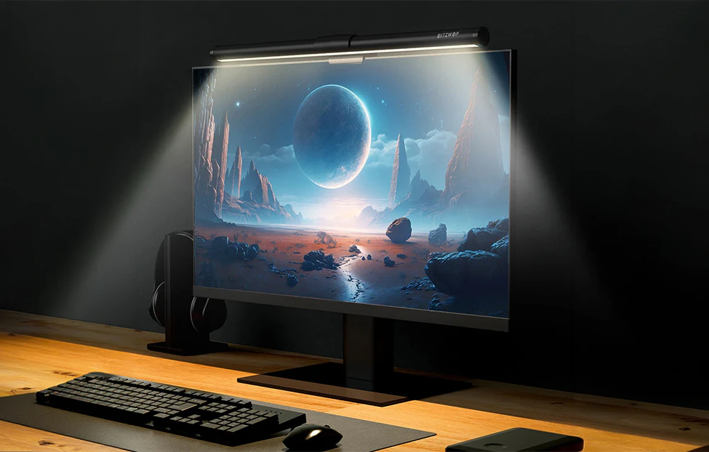 Birou cu un computer și o lampă atașată la monitor