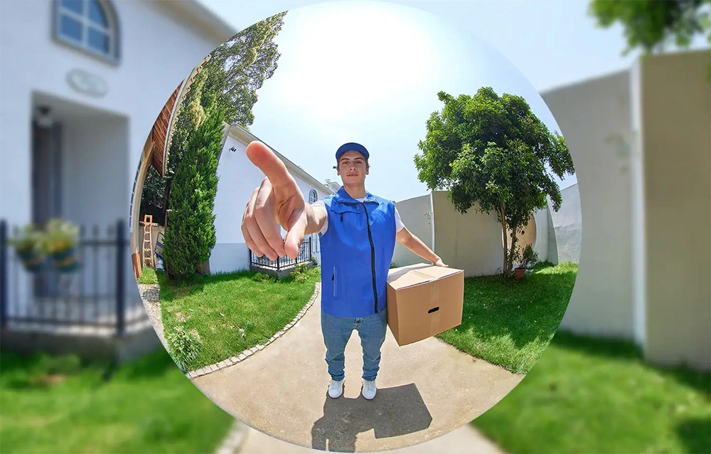 Imagine filmată cu camera fish-eye a unui curier îmbrăcat într-o vestă albastră, care ține un pachet și îndreaptă degetul spre obiectiv