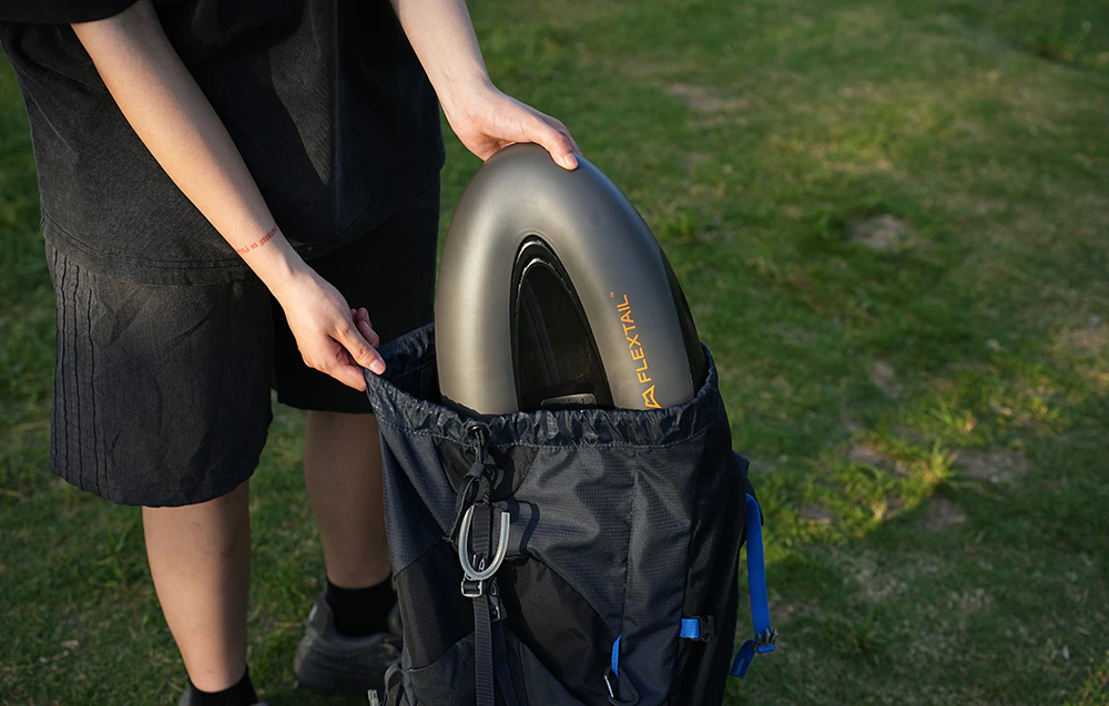 Flextail Evo SUP Pump Pro fiind așezat într-un rucsac pentru transport.
