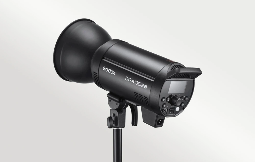 Studio foto, bliț Godox DP400III V cu un reflector negru atașat.