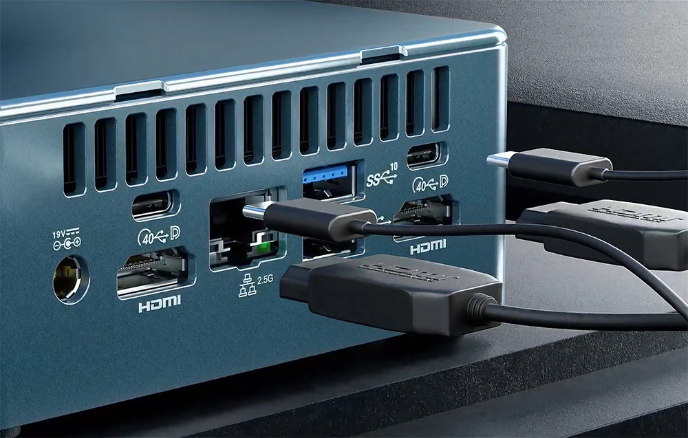 Cabluri conectate la porturile MINI PC, care se află pe un birou întunecat