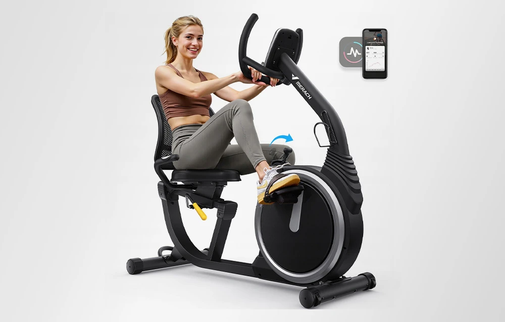 O femeie zâmbitoare pedalează pe o bicicletă de exerciții; pe smartphone-ul de lângă ea se vede pictograma unei aplicații mobile