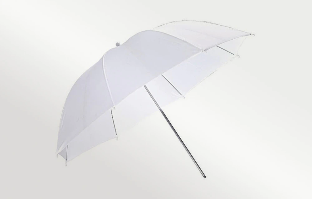 O umbrelă albă, deschisă, așezată înclinată pe un fundal deschis.