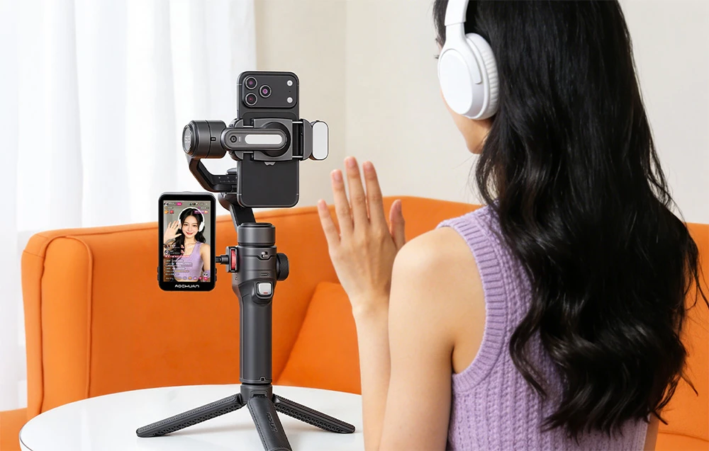 O femeie care poartă căști transmite live folosind un gimbal Aochuan pe un trepied