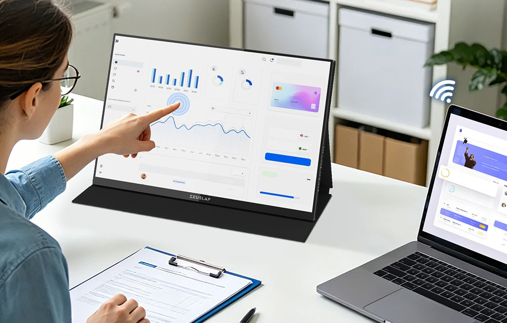 O femeie folosește ecranul tactil al unui monitor portabil ZEUSLAP conectat wireless la un laptop