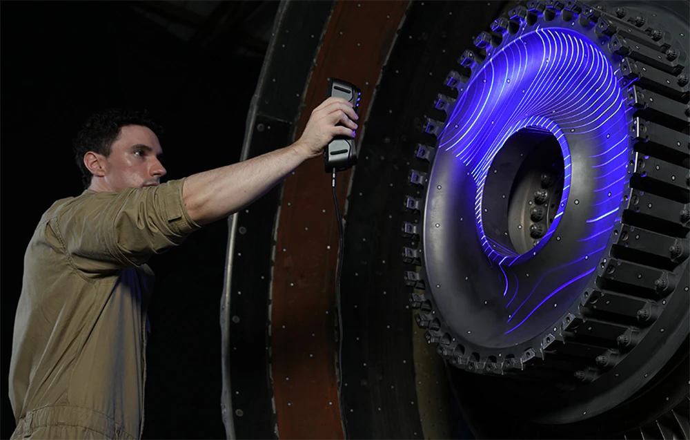 Un tehnician scanează o turbină cu o lumină de proiecție albastră clară.