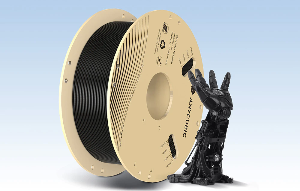 O bobină de filament negru pentru imprimanta 3D în poziție verticală lângă o mână mecanică neagră imprimată